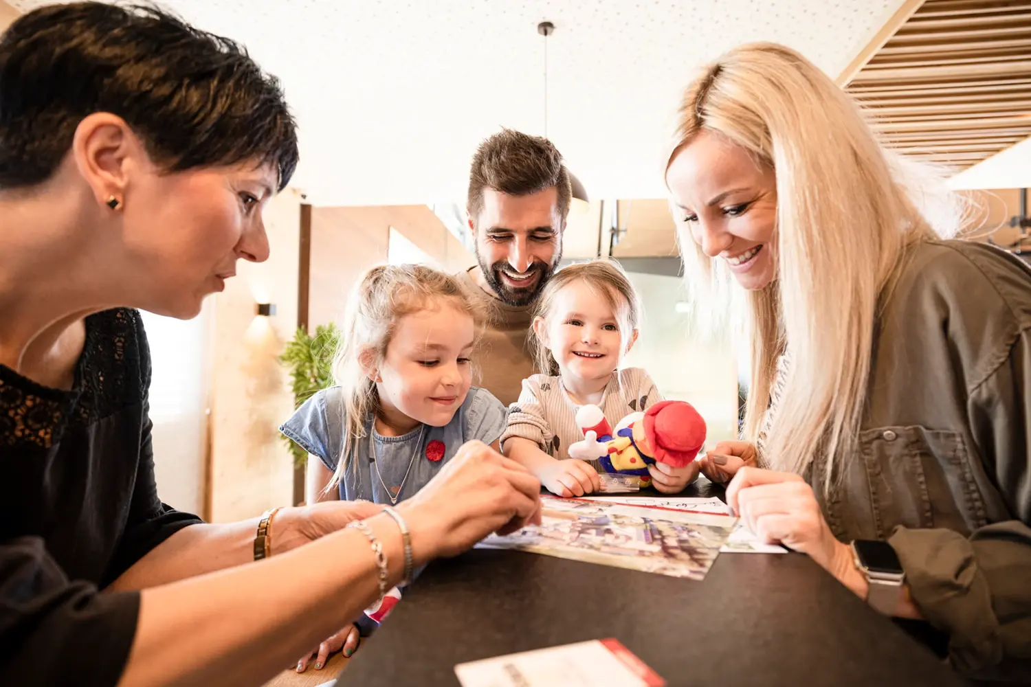 Familie mit zwei Kindern steht an der Hotelrezeption